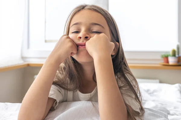 stock image Portrait of a charming little girl in bed early in the morning, healthy sleep concept.