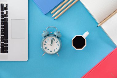 İş yerinde düzlük, çalar saat ve bir fincan kahve, çalışma ve öğrenim kavramı.