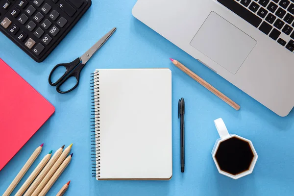 stock image Flat lay, notepad, laptop and stationery on blue background, copy space.