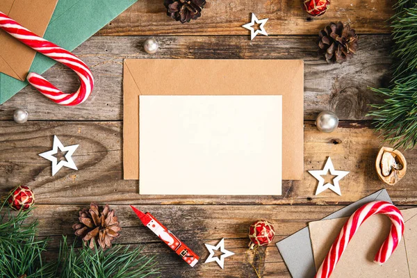 stock image Blank paper, envelope and Christmas decor details on wooden background, flat lay.