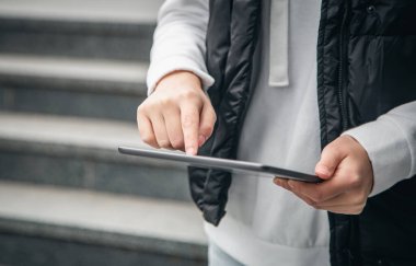 Kapatın, kadın tablet kullanıyor, şehir arka planı bulanık, vücut parçası.