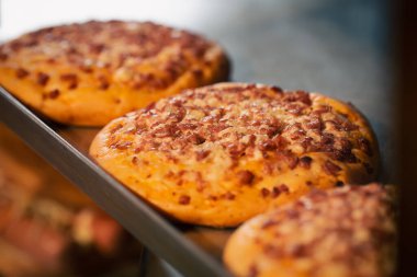 Fırındaki tezgahın üstünde yeni pişmiş mini pizza. Arka planda bulanık bir görüntü..