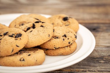Çikolata parçacıklı kurabiyeler bir tabakta, mutfakta masanın üstünde..