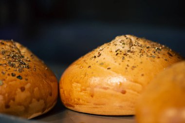 Yakın plan, fırına yakın plan otlarla serpiştirilmiş taze çörekler..