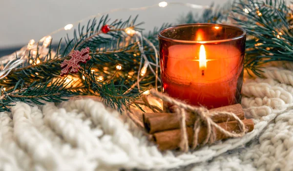 stock image Christmas composition with burning candle and cinnamon sticks on blurred background, copy space.