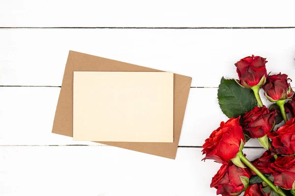 Envelope Folha Papel Branco Buquê Rosas Vermelhas Fundo Madeira Branco — Fotografia de Stock