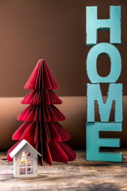 Dekoratif kelimelerle süslenmiş samimi kış kompozisyonu ve kağıt Noel ağacı yakın..