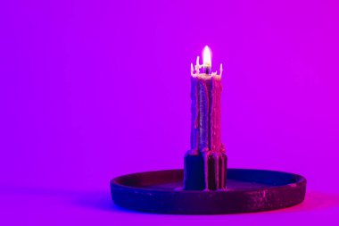 Pembe arkaplanda yanan mum desenli, neon ışıklı, kopyalama alanı.