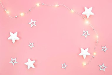 Çelenk ve dekoratif yıldızlı minimalist pembe Noel arkaplanı, düzlük, kopyalama alanı.
