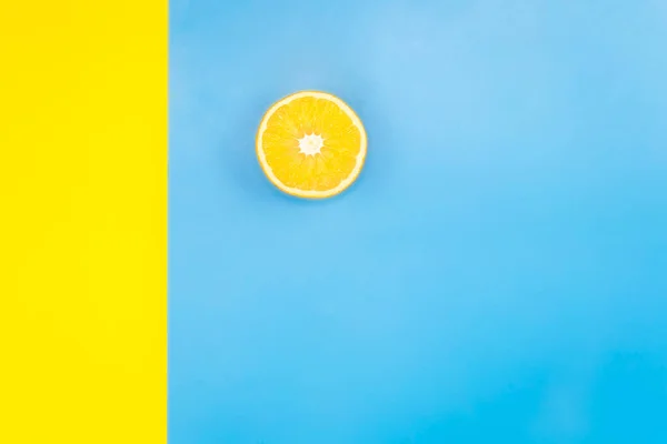 Połowa Pomarańczy Niebiesko Żółtym Tle Płaska Leżanka Minimalizm Przestrzeń Ksero — Zdjęcie stockowe