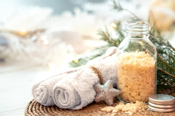 Winter spa composition with body care items and festive Christmas decoration details.