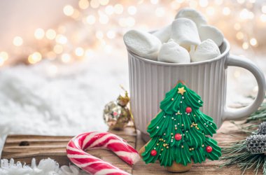 Noel arkaplanda bir fincan marshmallowlu kakao ve şenlikli dekorasyon ayrıntıları..