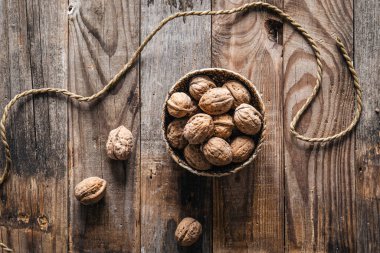 Ahşap arka planda ceviz dolu bir kase, düz yatış, kırsal tarzda..