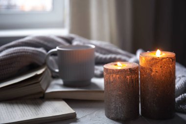 Odanın içinde bulanık bir arka planda mumlarla konforlu ev kompozisyonu, boşluğu kopyala.