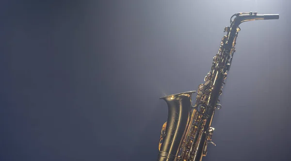Saxophone on a dark background with smoke, music background, copy space.