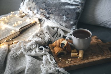 Bir fincan çay, mumlar ve kitaplarla rahat kompozisyon, boşluğu kopyala.