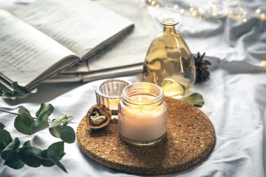 Yatağında mumlar ve kitaplar olan rahat ev kompozisyonu, boşluğu kopyala.