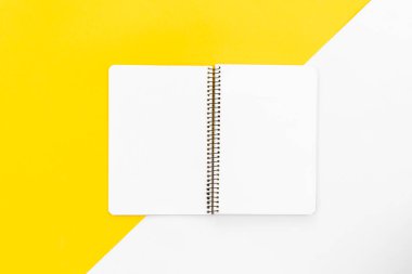 Renkli arkaplanda boş not defteri, düz yatış, kopyalama alanı.