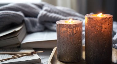 Odanın içinde bulanık bir arka planda mumlarla konforlu ev kompozisyonu, boşluğu kopyala.