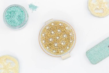 Kuru masaj için yuvarlak bir fırça ve beyaz arka planda vücut bakımı için diğer öğeler izole, üst görünüm.