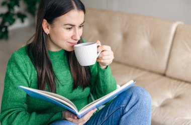 Evinde not defteri olan bir fincan kahvesi olan iş kadını..