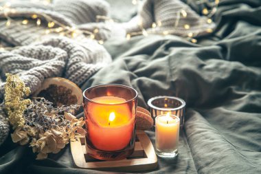 Yatağında mumlar olan rahat ev kompozisyonu bulanık arkaplanda, boşluğu kopyala.