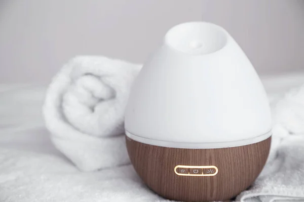 Modern oil aroma diffuser on blurred background. The concept of refreshing and purifying the air in the house.