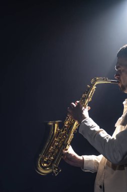 Sahnedeki erkek müzisyen siyah saksafon çalar dumanla, kopyalama alanıyla.