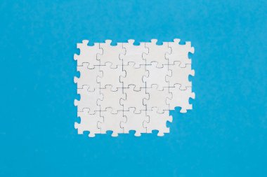 Mavi arkaplanda beyaz bulmacalar, düz yatış, kavramsal minimalizm, kopyalama alanı.