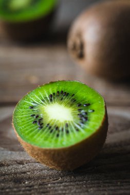 Yakın plan, ahşap arka planda meyve kivisi kesimi, kırsal tarz..