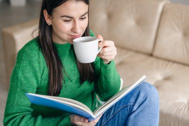 Evinde not defteri olan bir fincan kahvesi olan iş kadını..