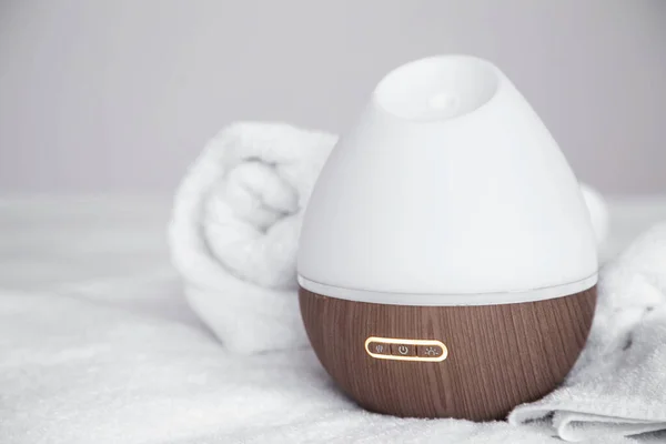 Modern oil aroma diffuser on blurred background. The concept of refreshing and purifying the air in the house.