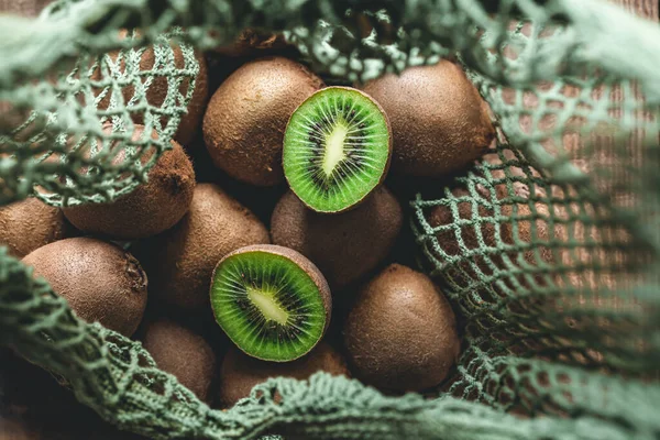 Fruits of kiwi in a mesh bag, top view, close -up, concept of ecology and healthy diet.