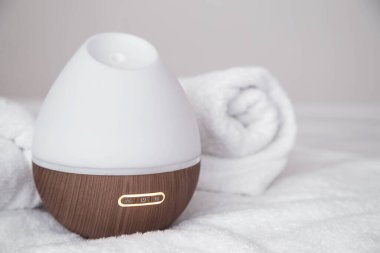 Bulanık arka planda modern yağ aroması yayıcı. Evdeki havayı tazeleme ve arındırma kavramı..