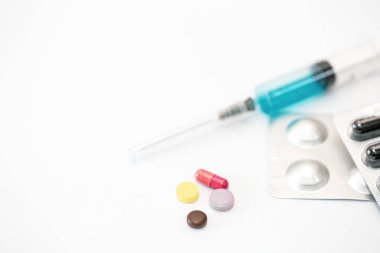 Beyaz arkaplandaki şırınga ve haplar izole edilmiş, yakın plan, kopyalama alanı.