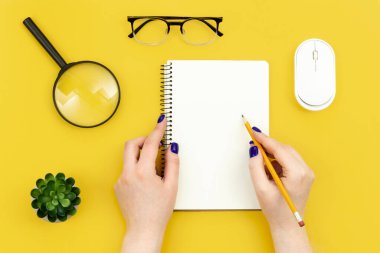 Sarı arka plan, düz alan, hobi, iş ve yaratıcılık kavramı, kopyalama alanı üzerindeki boş not defteri.