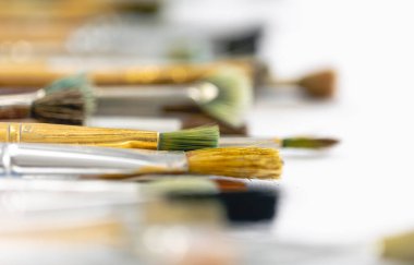 Paint brushes stained with paint, macro shot, soft focus, drawing and art concept.