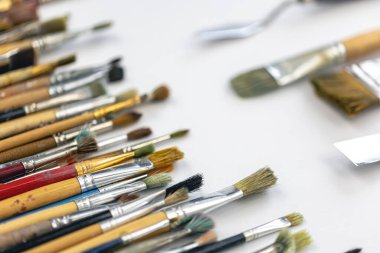 Paint brushes stained with paint on a white background, macro shot, soft focus, drawing and art concept.