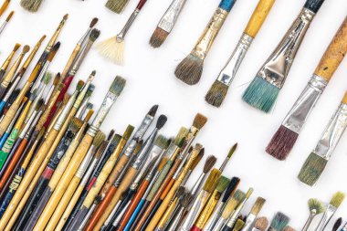 Many colored brushes for painting on a white background isolated, top view.