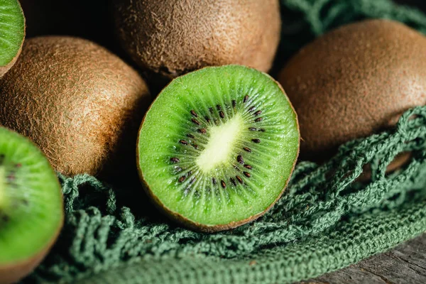 Kiwi fruits in a mesh bag, close -up, rustic style, eco concept.