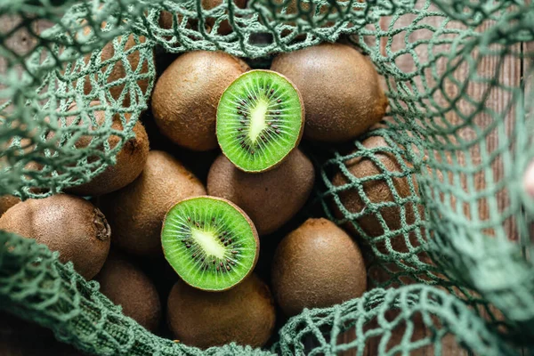 Fruits of kiwi in a mesh bag, top view, close -up, concept of ecology and healthy diet.