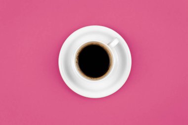 Coffee cup and saucer on a pink background, flat lay, conceptual minimalism.