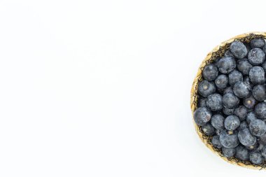 Blueberries in a plate on a white background isolated, top view, copy space.