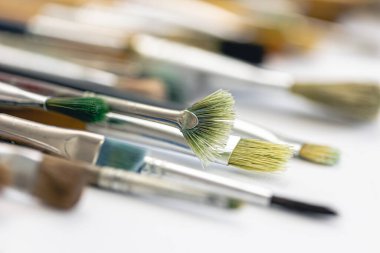 Paint brushes stained with paint, macro shot, soft focus, drawing and art concept.