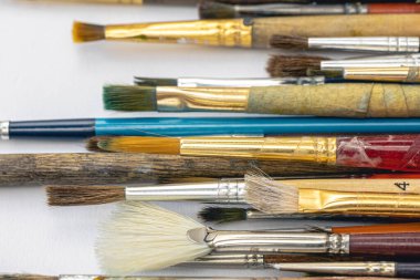 Close-up, old paint brushes on a white background, the concept of drawing and art.