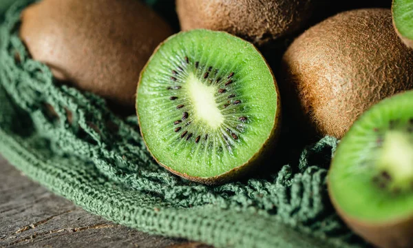 Kiwi fruits in a mesh bag, close -up, rustic style, eco concept.