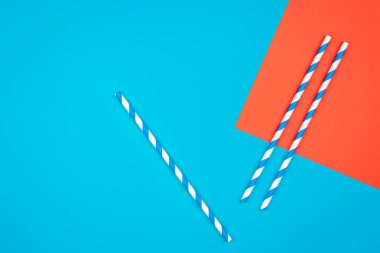 Drinking straws for party on colored background. Top view of colorful paper disposable eco-friendly straws for summer cocktails.