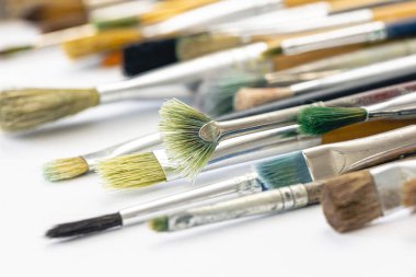 Paint brushes stained with paint, macro shot, soft focus, drawing and art concept.