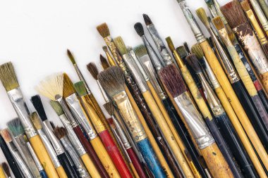 Many colored brushes for painting on a white background isolated, top view.