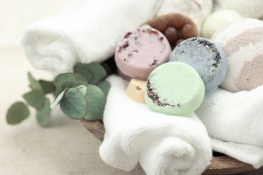 Spa composition with colorful round handmade soaps and towels close-up.